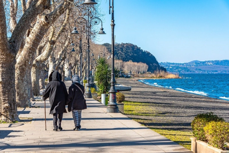 A couple walks along the lake in Bracciano